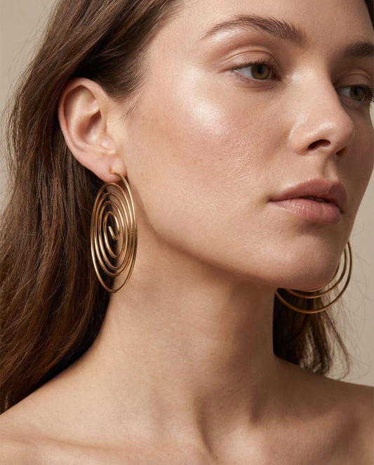 fluid metallic spiral earrings worn by model