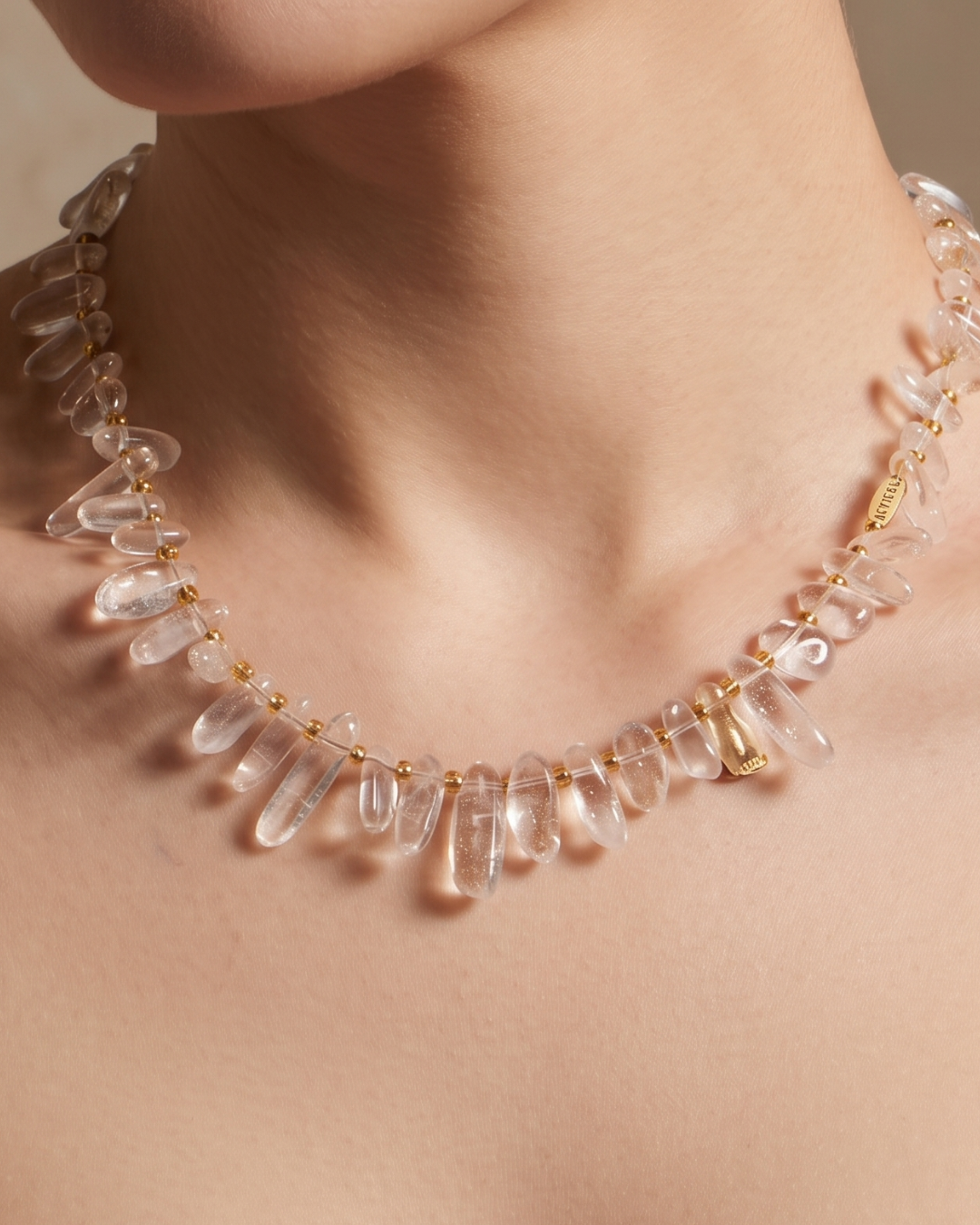 Tracy necklace in frosted white worn at the collarbone, irregular stone beads with gold accents