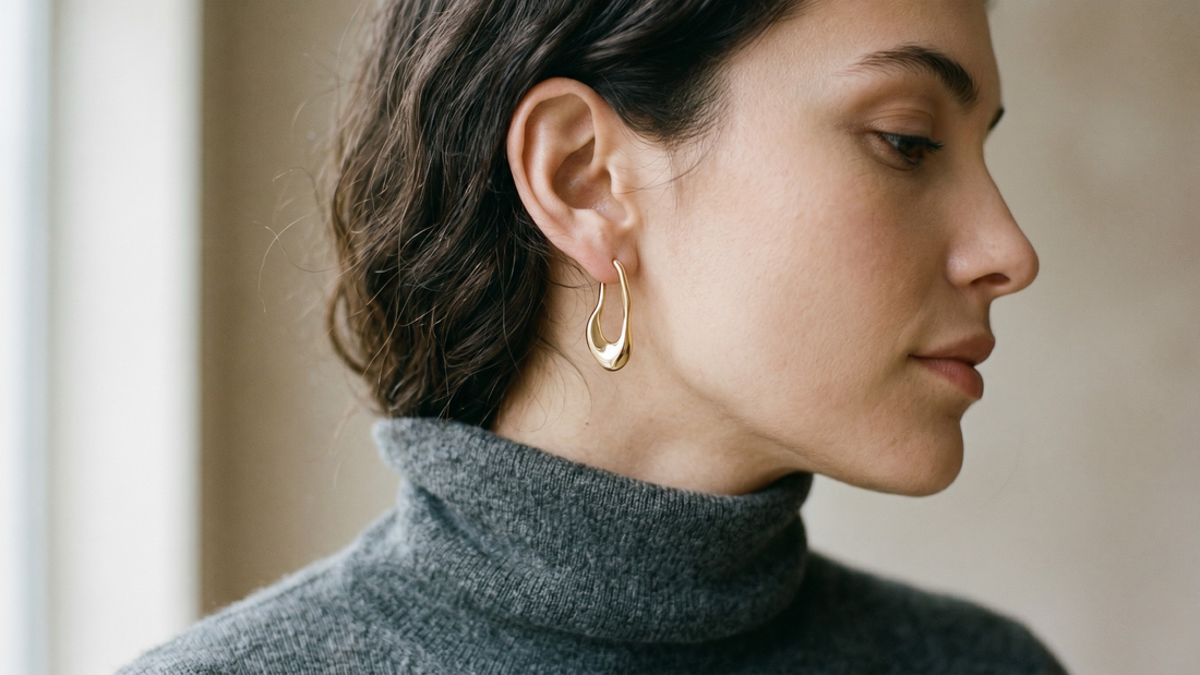 Close-up of woman wearing gold earring — what your earring choice says about where you are in life