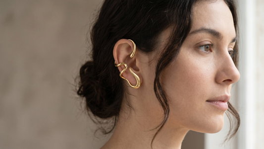 Gold sculptural ear cuff worn on ear — complete guide to ear cuffs 2026