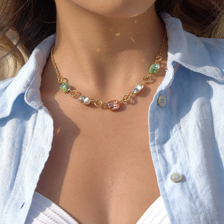 Alba necklace worn at the collarbone, five emerald-cut crystal stones in graduated colours