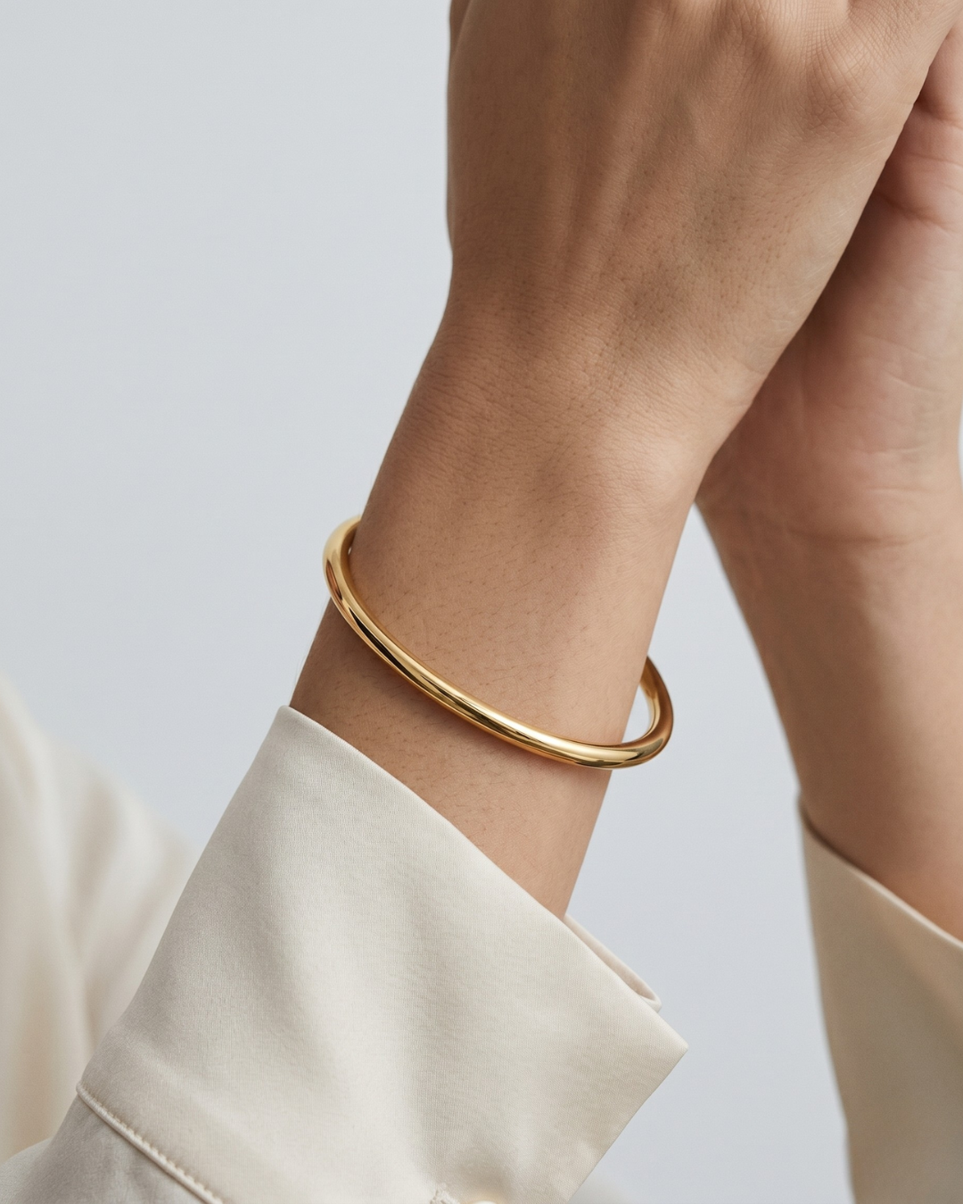Amélie bangle worn on the wrist, clean tubular round silhouette