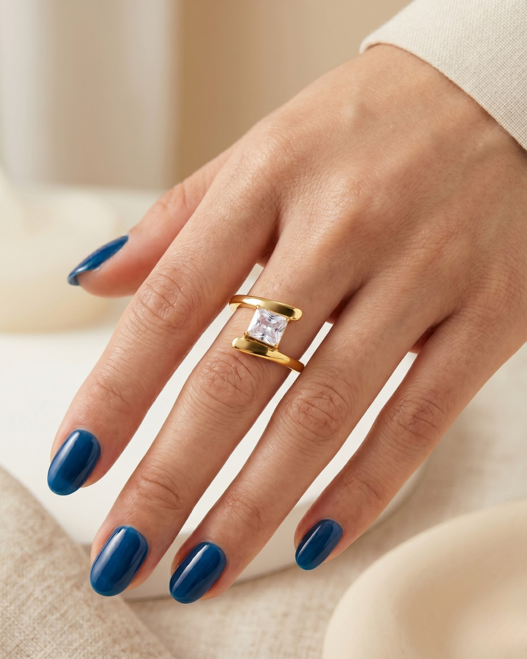 Astrid ring worn on the finger, sculptural double band framing a square-cut stone