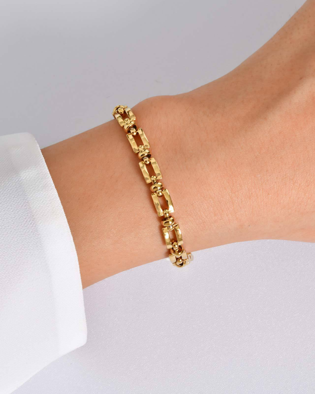 Beatrice bracelet worn on the wrist, rectangular gold links with beaded spacers