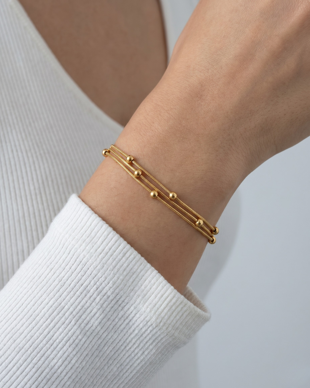 Gold electroplated stainless steel triple layer snake chain bracelet with ball bead accents by Clarabelle