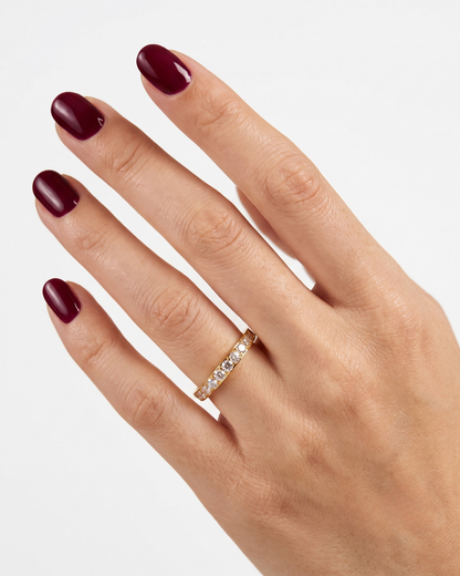 Close-up of Serena ring, crystal-set pavé stones along a slim gold-finished band