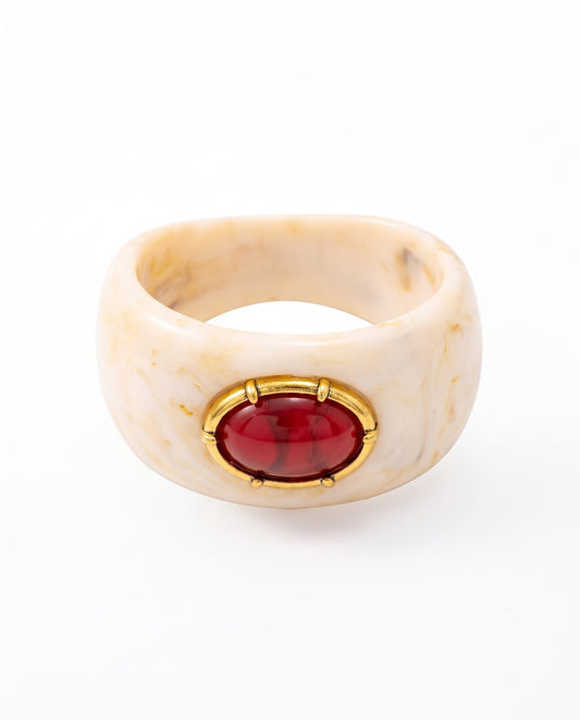 Cosima resin statement cuff in marbled teal with red cabochon centrepiece and ornate gold-tone bezel setting, laid flat on neutral background