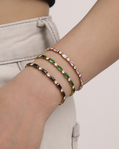 Noor tennis bracelet worn on the wrist, alternating baguette and round crystal stones in 18k gold plating