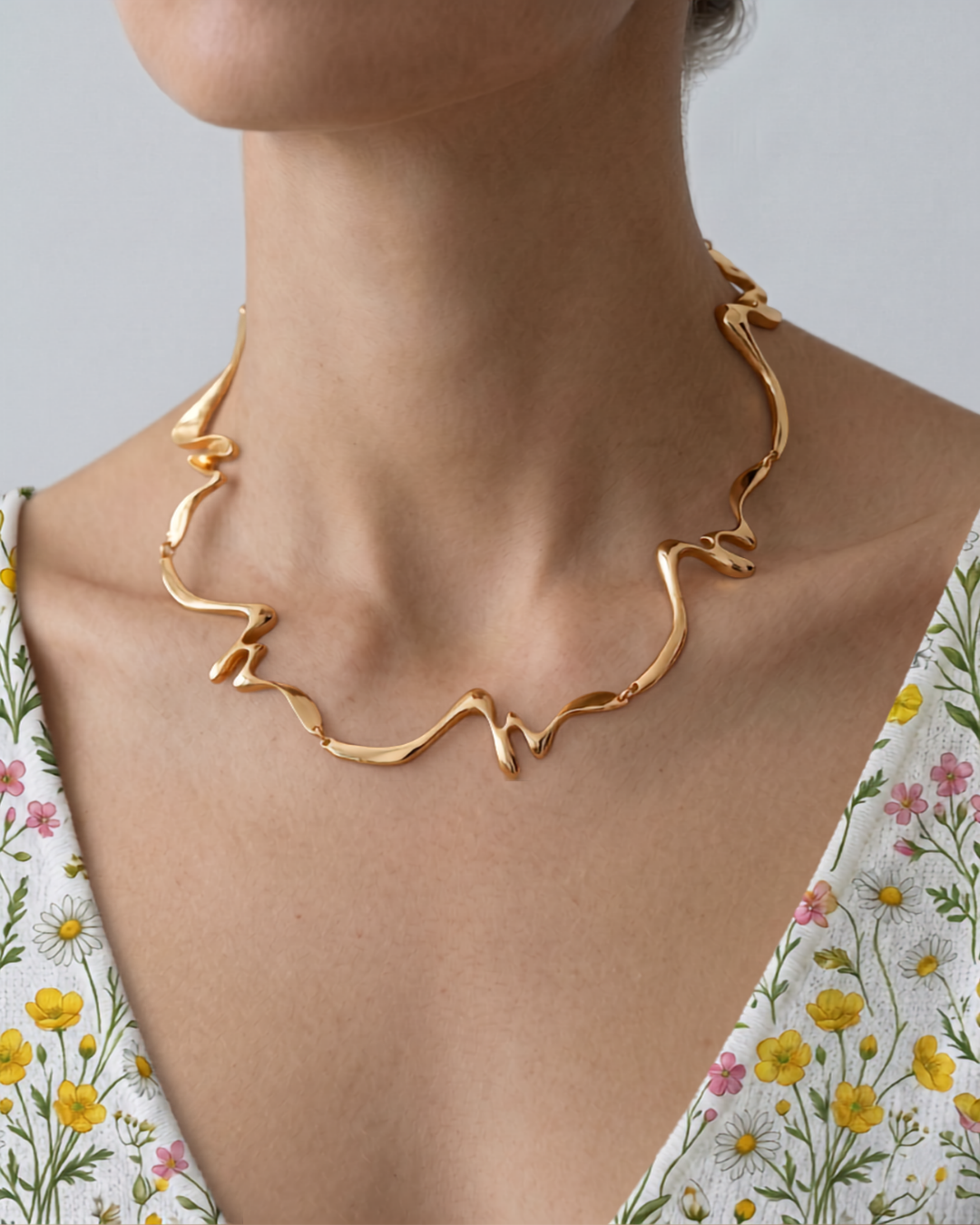 Close-up of Maiorca necklace, irregular sculpted curves in gold finish
