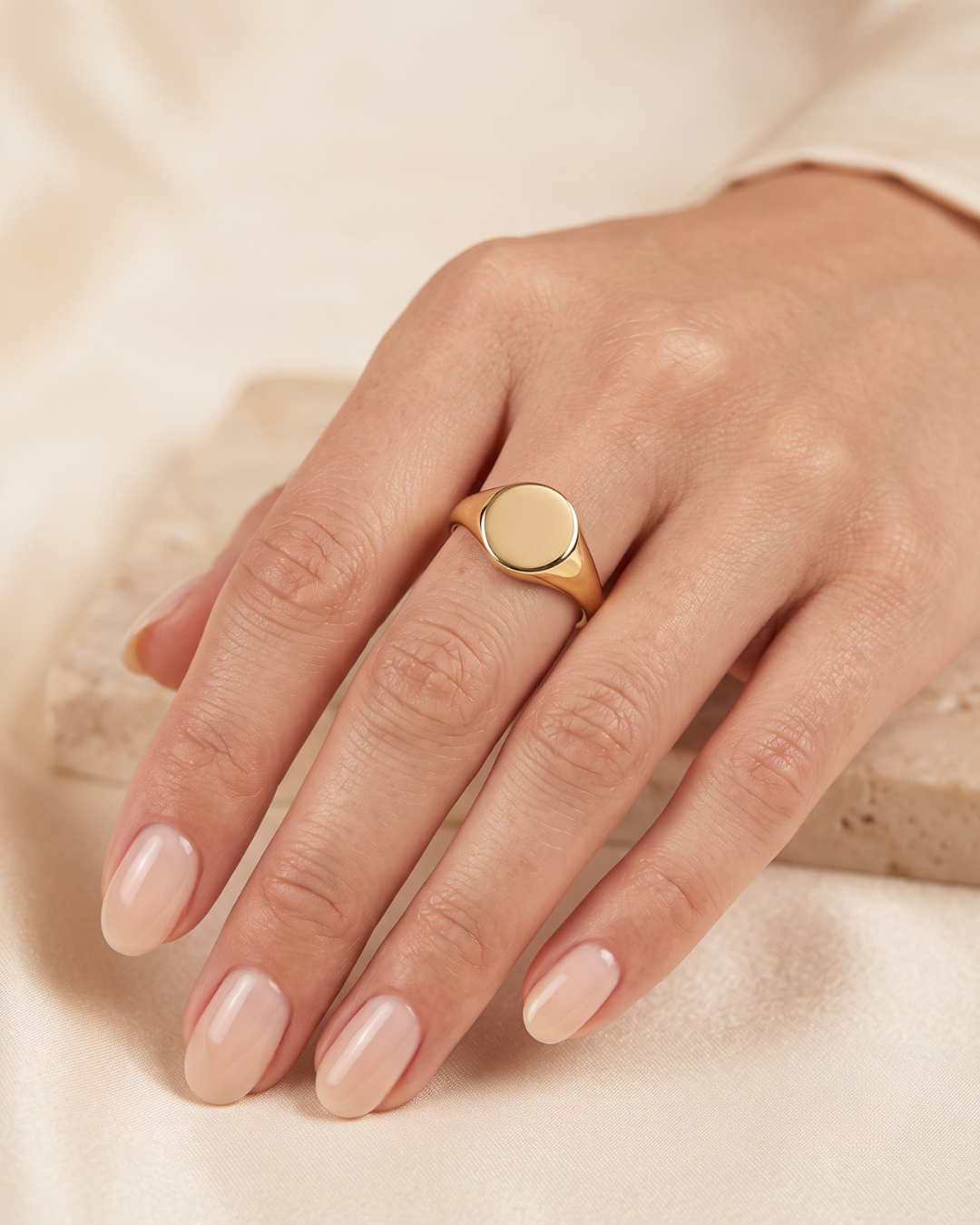 June gold ring worn on the finger, round polished face on a slim band