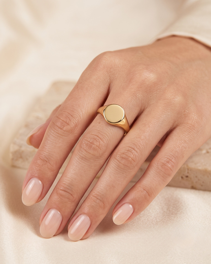 June gold ring worn on the finger, round polished face on a slim band
