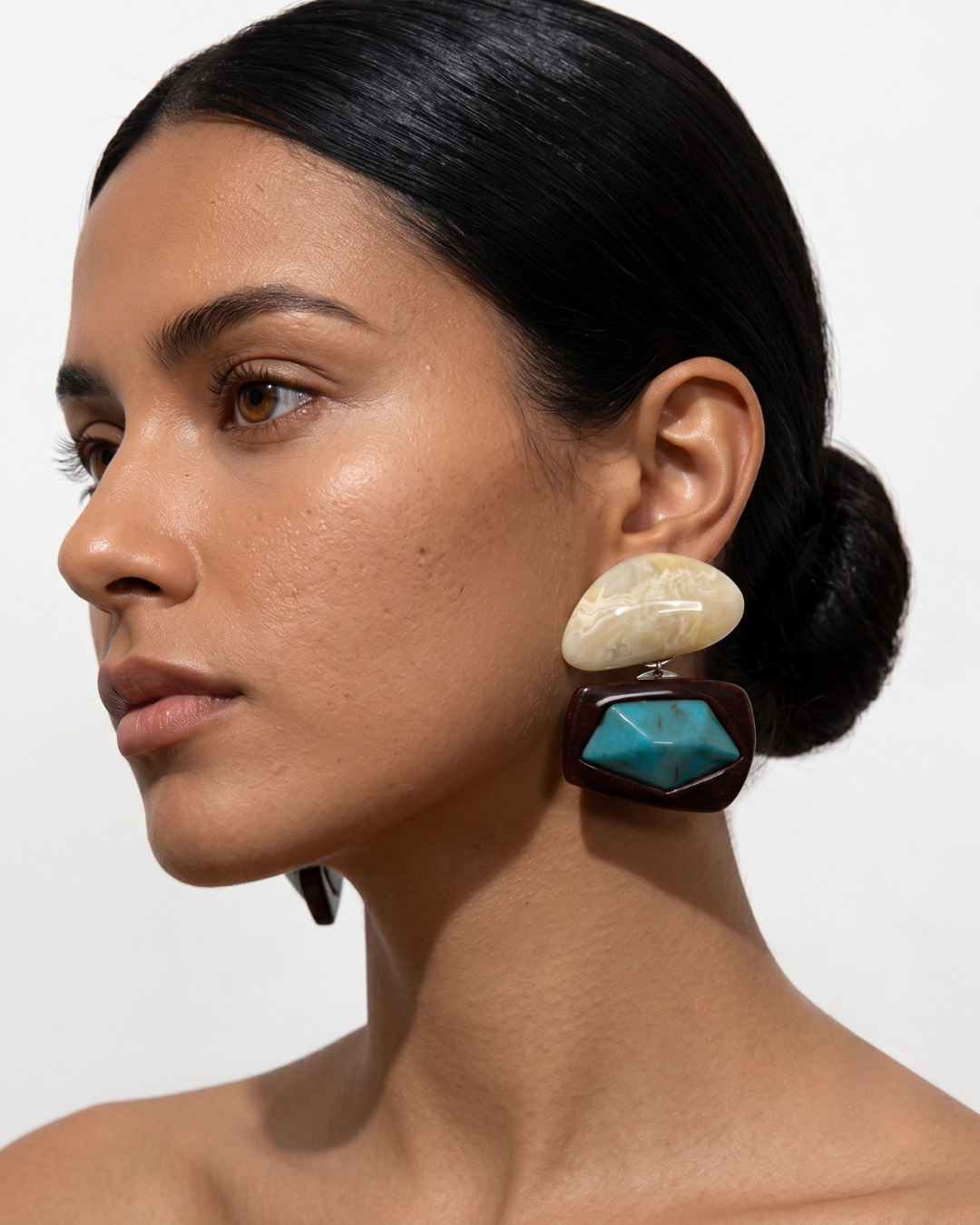 Malika earrings worn at the lobe, statement two-part drop falling to the jawline