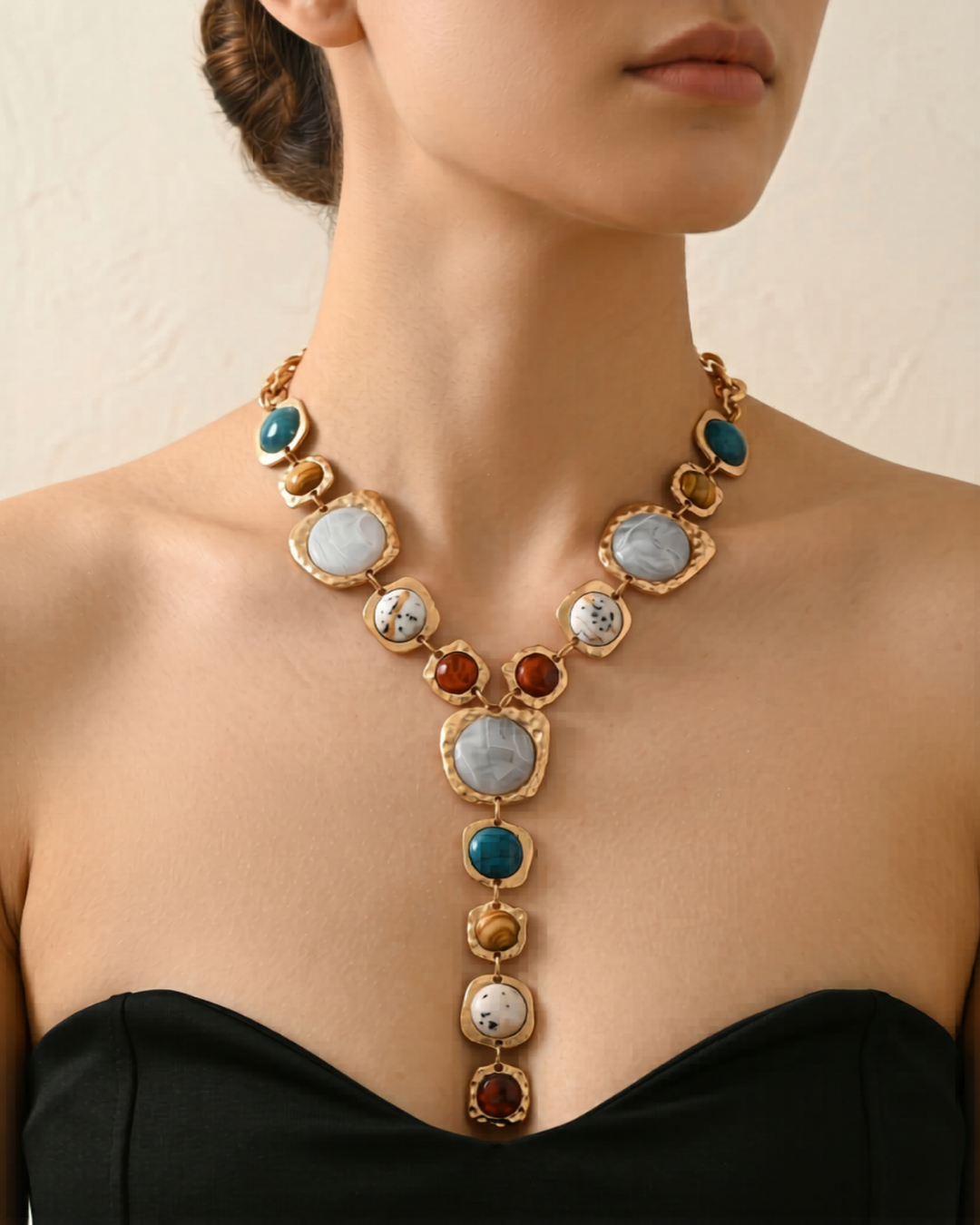 Gold statement necklace with multicolour stone-effect pendants worn on model by Clarabelle