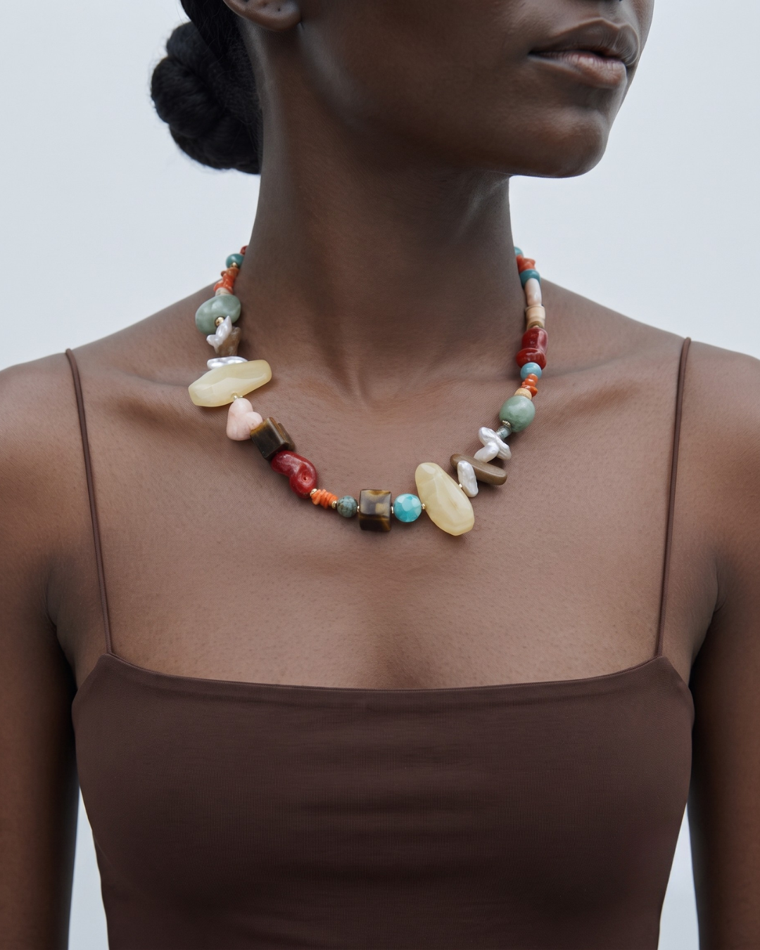 Nala necklace worn at the base of the throat, mixed-colour beaded strand with resin and accent stones