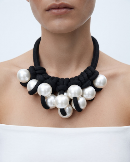 Simone necklace worn at the base of the throat, cluster of pearl pendants against black textile cord