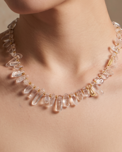 Tracy necklace in frosted white worn at the collarbone, irregular stone beads with gold accents