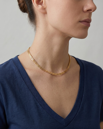 Woman wearing a gold flat mesh chain necklace on neck, minimal white top, soft natural light — Spello Necklace by Clarabelle
