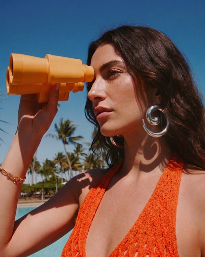 Model wearing silver statement earrings by the pool with summer outfit, bold jewellery styling